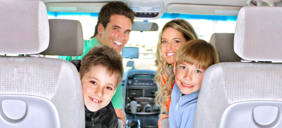 A happy family of two adults and two young boys smiling