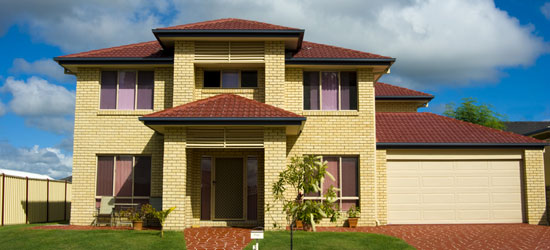 A two story home sitting on lush green land with a mailbox